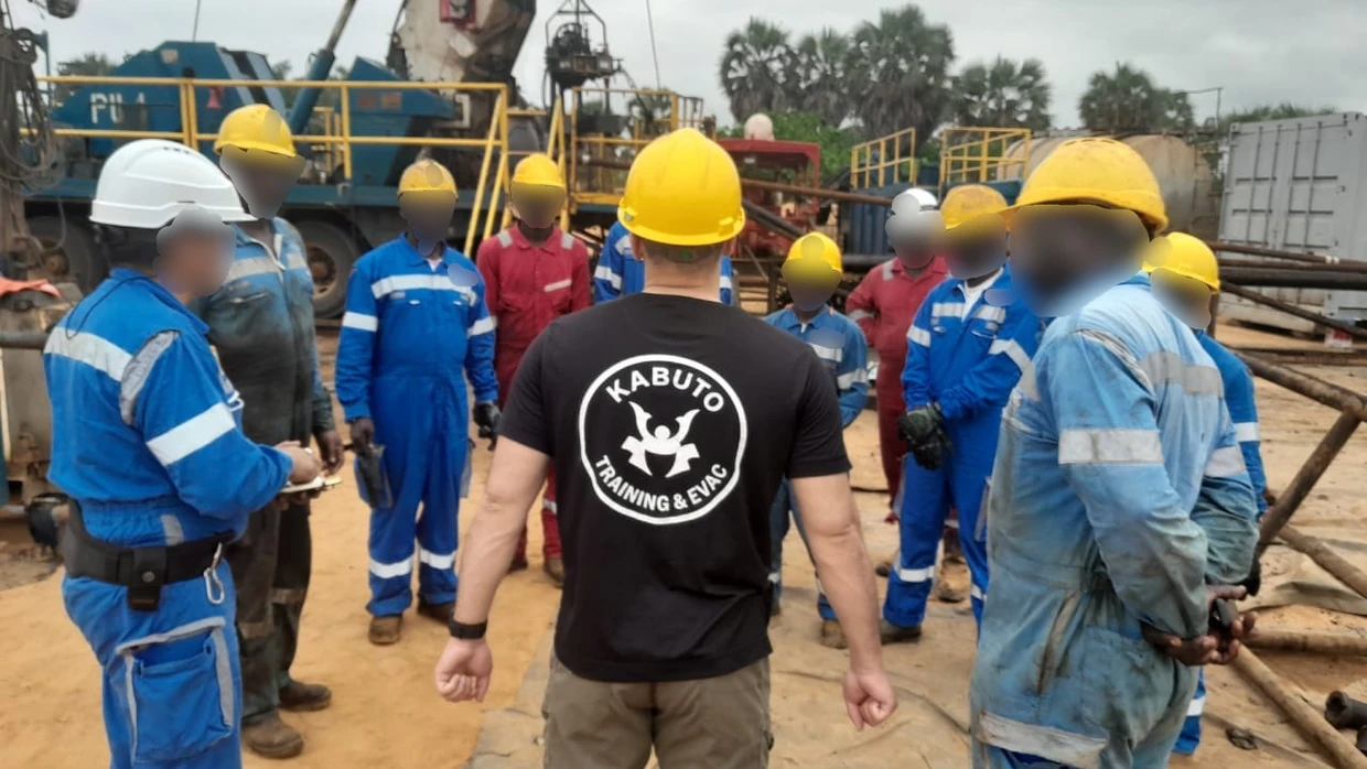 Briefing d’équipe au pied d’un derrick de forage